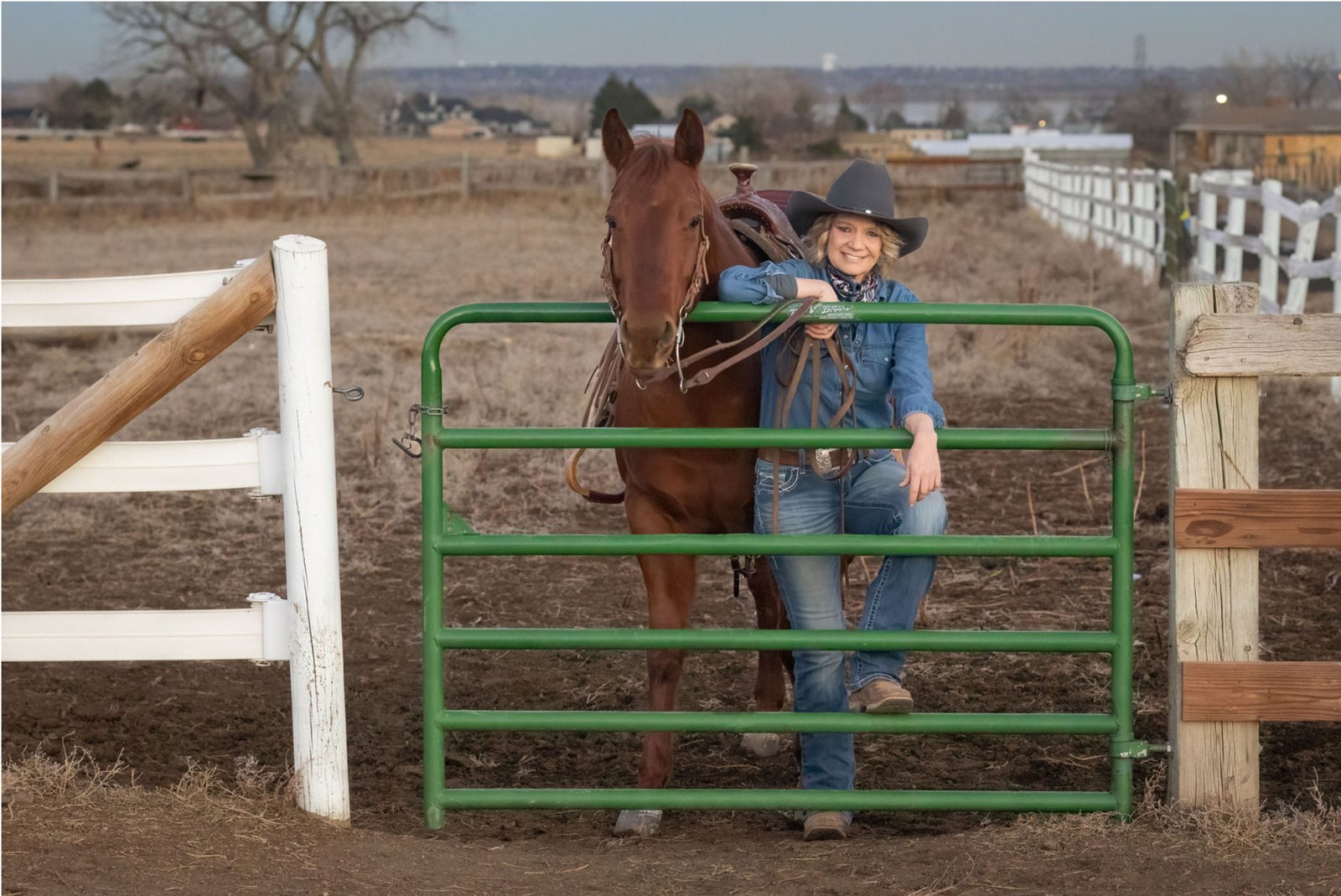 EquiZenergy founder Christina Barlament with a saddled horse at a ranch gate